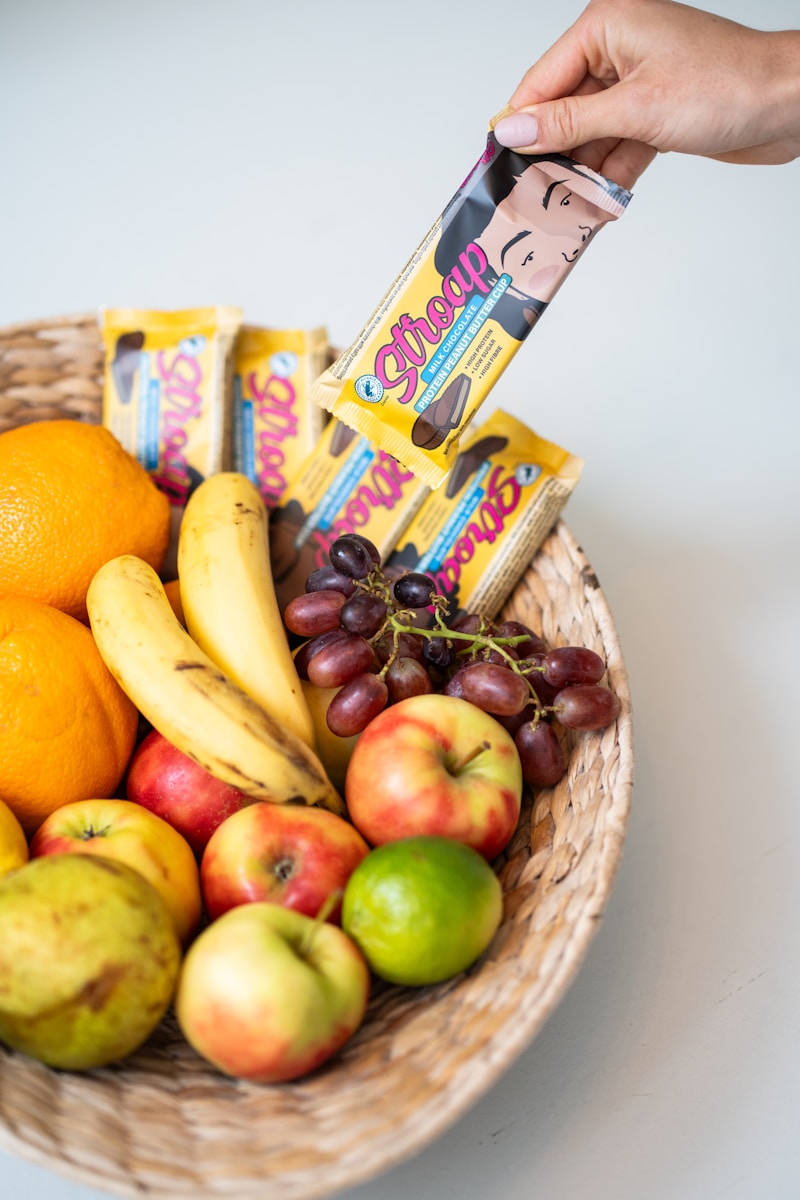 a basket filled with fruit and a hand holding a bar